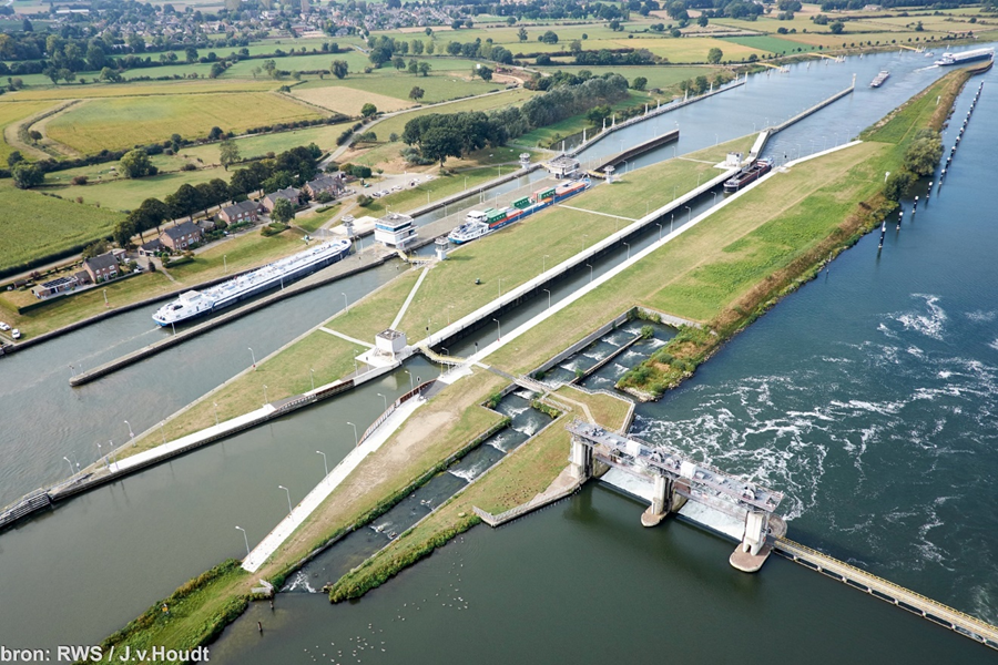 Luchtfoto stuw- en sluiscomplex Sambeek met in het midden in beeld de vistrap die om de stuw heen loopt.,